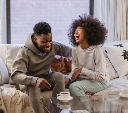 couple laughing on sofa together