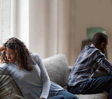 couple facing away from each other on sofa